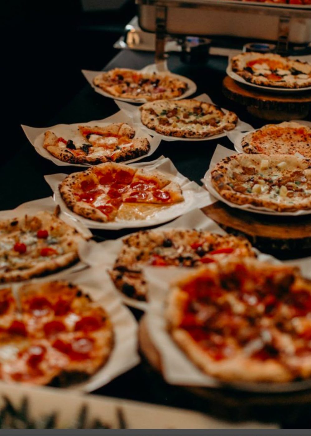 Mesa de catering con variedad de pizzas Doca's