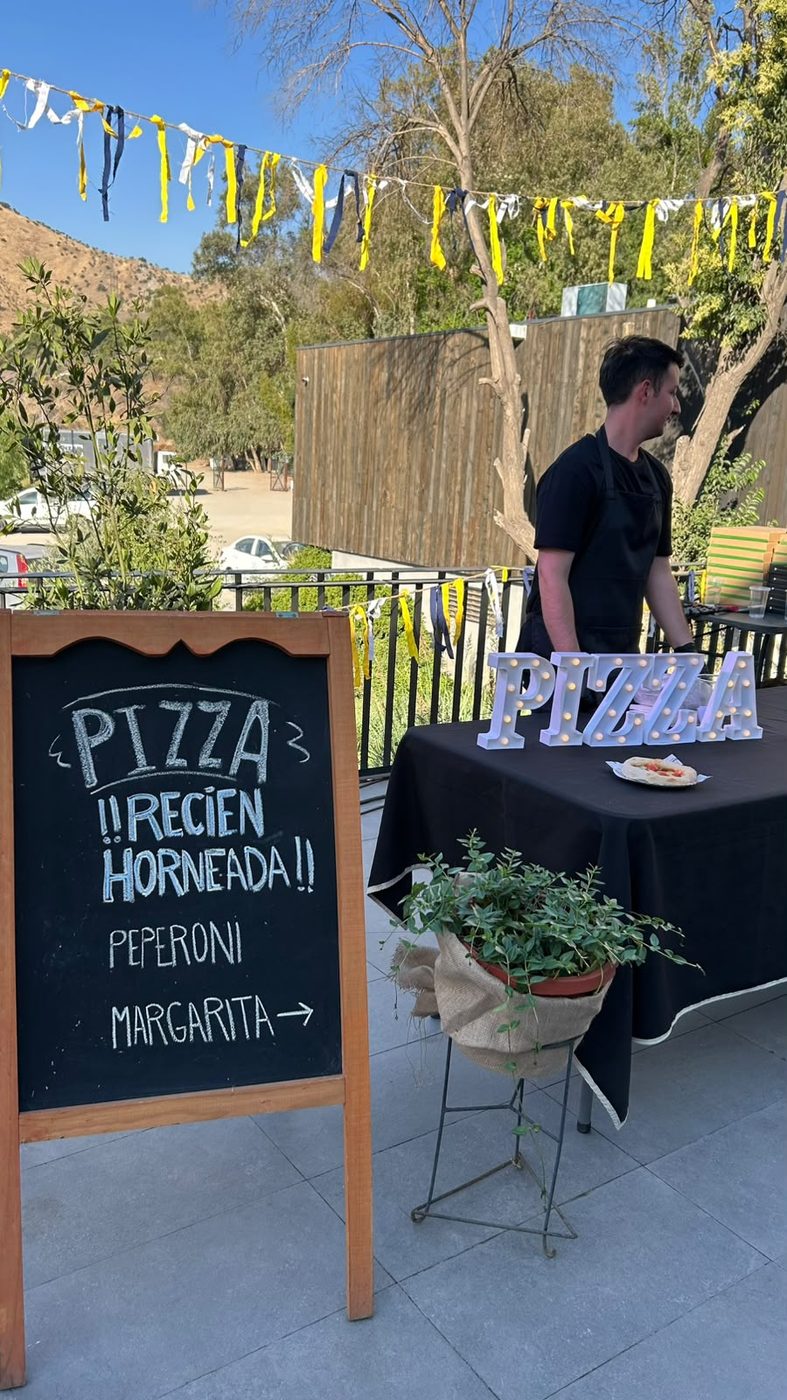 Letrero de pizza recién horneada en evento Doca's